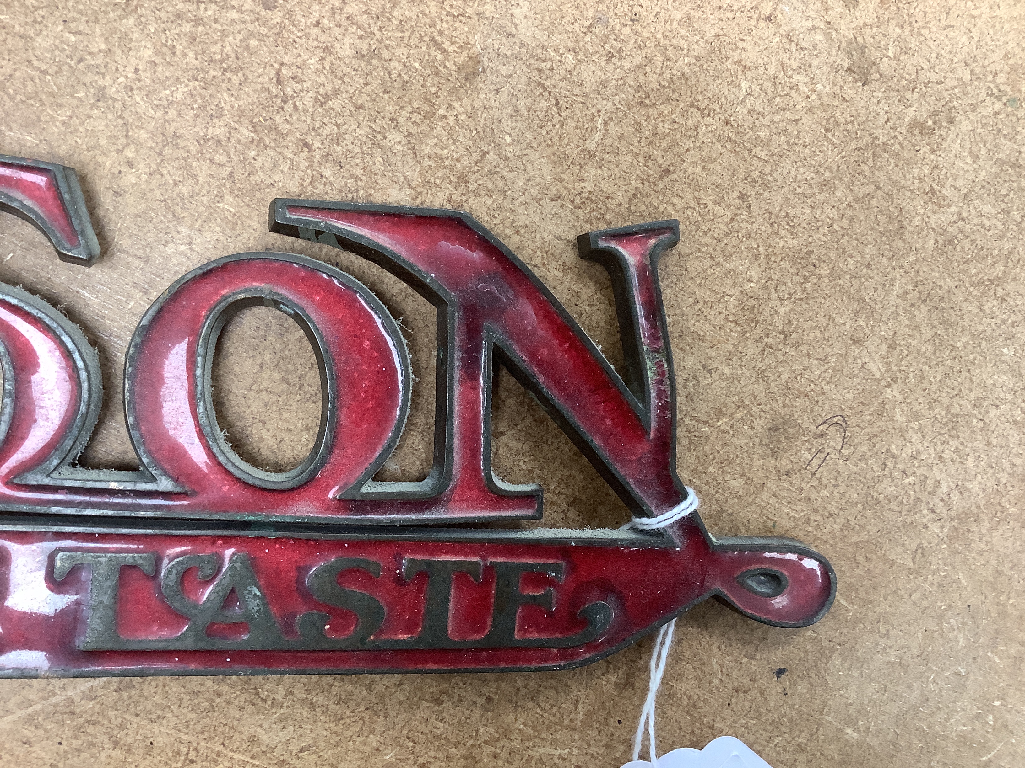 An enamelled bronze 'Montague Burton The Tailor of Taste' shop sign, 41cm wide
